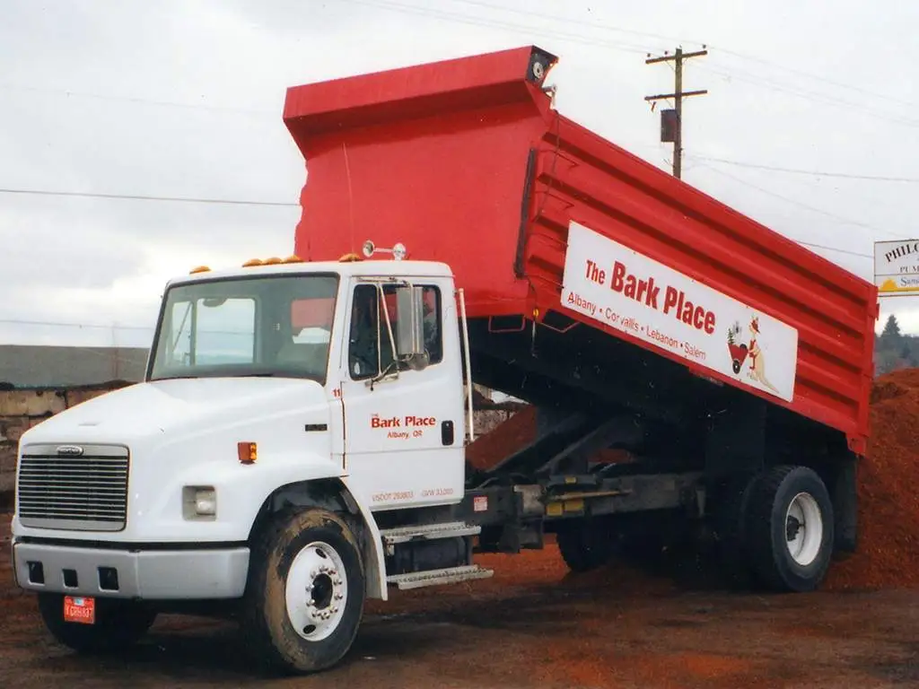 The Bark Place red dump truck with its bed raised