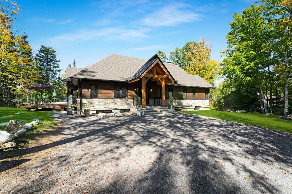 A crushed-rock driveway in front of a timber-frame house